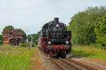 Lok 86 1333 mit Historischen Fahrzeugen als sogenannte ZU|G|BRINGER an diesem Wochenende zwischen Bergen und Putbus ,mit Haltepunkt Lauterbach im Hintergrund. - 25.07.2024

