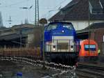 Locon 219 (203 559-0) verlt am 11.01.2013 mit einem mit Abraum beladenen Niederbordwagenzug die Baustelle in Aachen West nach Stolberg.
