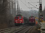 Am 03.03.2012 steht 212 370-1 der EfW-Verkehrsgesellschaft mit einem vollgeladenen Flachwagenzug mit Betonschwellen auf der KBS 480 bei Aachen Rothe Erde und wird von zwei Baggern entladen.