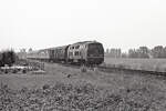 DB 215 021-7 mit E-2417 (Nijmegen - Stuttgart Hbf) bei Nütterden am 11.07.1977. Mit im Zug auch einen Behelfspackwagen MDyg986. Bild 91107.