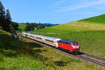 Am 23. August 2024 ließ ich mich zu einem Ausflug ins Ostallgäu überreden. Ziel sollte sein, die orientrote 218 406 vor dem IC-Zugpaar 2084/85 zu fotografieren. Im Nachhinein bin ich sehr froh, die Tour unternommen zu haben, konnte dadurch doch unwissentlich eine der letzten Fahrten des  Nebelhorns  auf der Allgäubahn dokumentiert werden. Wenige Tage später verkehrte die Verbindung zum letzen Mal. Es trat beim Stellwerk in Oberstdorf ein gravierender Schaden auf, die Weichen zu den Abstellgleisen mit der Zugvorheiz-Anlage können nicht mehr angesteuert werden. Die Reparatur scheint so aufwändig zu sein, dass man lieber gleich das Fernzug-Angebot eingestellt und für 2025 gar nicht erst bestellt hat. Alternative Möglichkeiten zur Abstellung und zur Zugbehandlung gibt es im Allgäu ebenfalls keine mehr. Was wie ein Schildbürgerstreich klingt, ist leider symptomatisch für den Zustand der Deutschen Bahn. Am besagten 23. August 2024 kam die mustergültig in den Zustand der frühen Epoche V zurück versetzte 218 406 mit ihrem IC 2084 nach Hamburg Altona fast pünktlich die Günzacher Steige hinauf gefahren und konnte von mir bei Mittelberg aufgenommen werden. Die zwei Kühe ließen sich von der Durchfahrt des Zuges nicht irritieren - als hätten sie es geahnt, dass sie künftig beim Grasen ohnehin nur noch von Triebwagen der Baureihen 612 und 633 und mit viel Glück (aus Sicht eines Eisenbahnfreundes) durch einen Güterzug gestört würden.  