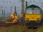 Ein Atlas 2Wegebagger von Eiffage Rail zieht einen Anhnger mit Werkzeug am 07.10.2010 durch Aachen West zur Gleisbaustelle. Rechts steht die Class66 V265 von der Rurtalbahn.