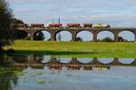 Auf dem Weg über die Rheinbrücke in Richtung Duisburg-Hochfeld spiegelt sich die 277 031-1 von Schweerbau am 12.10.2024 in den überschwemmten Wiesen des Rheinvorlandes