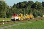 364 578 mit einer Schotterplaniermaschine und einer Gleisstopfmaschine der DB Bahnbau Gruppe am Haken bei Helmsheim.