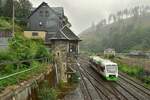 VT116 erreicht von Neuhaus am Rennsteig kommend im Nieselregen den Bahnhof Lauscha und passiert das alte Stellwerk. Das Stellwerk der Bauart Jüdel ging 1912 in Betrieb und wurde am 22.1.1997 außer Betrieb genommen und durch ein ESTW ersetzt. Das Gebäude ist verkauft und heute bewohnt oder anderweitig genutzt. Man beachte zudem das Dampflok Motiv an der Häuserwand. Das Bild wurde von einem Fußgängerweg aus aufgenommen.

Lauscha 02.08.2023