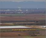 Messzug Nbz 94321 mit 120 160-7 Hockenheim-Basel. Ein Riegel an Industrie markiert die Grenze zu Frankreich. Auggen, Februar 2019.