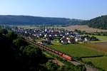 Blick auf die Ortschaft Breitenfurt im Altmühltal: Mit einer langen Schlange zweiachsiger Fcs-Wagen rollt 152 051 durch die malerische Landschaft.