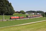 185 012 mit einem gemischten Güterzug aus Freilassing kommend am 22. August 2023 bei Axdorf/Traunstein.