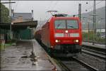 Whrend der Regen wieder zugenommen hat, druchfhrt die 185 017 mit einem Gterzug aus Kreuztal den Bahnhof Plettenberg Richtung Hagen.
