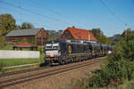 193 797 mit schönen schwarzen, farblich gut zur Lok passenden Waggons in Richtung Tschechien fahrend am 09.10.2024 am Fachwerkhaus neben dem in Fahrtrichtung 3. Rathener Bahnübergang.