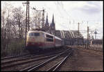 103105 hat mit dem IC 500 Heinrich der Löwe Köln HBF verlassen und fährt hier am 25.3.1993 vor der Kulisse der Hohenzollernbrücke und den Türmen des Doms in Köln Deutz ein.