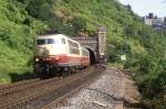 103 215 vor einem Avmz aus der Rheingold-83 Serie bei der Ausfahrt aus dem Tunnel St. Goar im Sommer 1986. Auf der anderen Rheinseite ist die  Burg Katz  auszumachen.