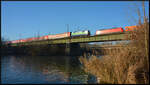 Die 111 074-1 (Touristik) mit dem Doppelstockzug von DB Gebrauchtzug und der 111 067-5 am 17.12.2022 als TRI-Ersatzzug für Go-Ahead Baden-Württemberg auf der Mainbrücke zwischen Heidingsfeld und Würzburg. Auf dem Gegengleis schiebt sich die 185 002-3 mit einem Containerzug langsam ins Bild.

