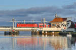 Eine mir unbekannte Elektrolokomotive der Baureihe 112 schiebt den aus Stralsund kommenden RE3 über die Eisenbahnbrücke in Anklam.