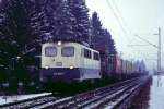 140 038 und 194 084 sind bei Prien in Richtung Salzburg unterwegs, 12.01-1985.