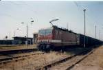 143 070 mit einem belgischen Containerganzzug mit Autoteilen fr eine schwedische Automarke nach Sassnitz Hafen im August 1997 in Velgast.Noch war der Bahnhof nicht umgebaut,die 143 zogen noch Gterzge und auch der Containerzug fuhr noch ber diese Strecke.