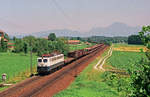 Vor der Kulisse des Gaisberges befördert Lok 150 018 am 20. Juli 1991 bei Straß einen Güterzug  in Richtung Rosenheim