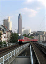 Im Hintergrund der Messeturm -    Einfahrt einer S-Bahn der Baureihe 420 in den Frankfurter Westbahnhof.