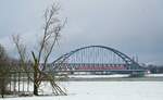 Wintereinbruch am Niederrhein: Blick vom Neusser Rheinufer auf die Hammer Eisenbahnbrücke, die gerade ein unbekanntes 422-Doppel am 09.01.2025 auf der Fahrt in Richtung Düsseldorf überquert