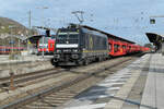 Mit einer langen Reihe leerer Pkw-Transportwaggons durchfährt die 185 567 der Beacon Rail den Bahnhof Treuchtlingen.