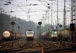 185 581-6 von Crossrail steht in Aachen-West mit einem Containerzug,  rechts daneben steht die Cobra 2818 mit einem gemischten Gterzug bei Wolken am 24.2.2012.