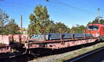 DB Cargo mit einem Drehgestell-Flachwagen mit sechs Radsätzen, mit Rungen, Stirnwandklappen und klappbaren Ladeschwellen, jedoch ohne Seitenwandklappen, mit der Nr.