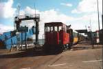 Die Inselbahn Borkum ist am Hafen angekommen,die Lok hat Kopf gemacht und sich wieder an die Ort-Seite gesetzt.Allerdings muss vor der Abfahrt das Ankommen der Fhre aus Emden abgewartet werden.