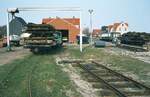 Inselbahn Spiekeroog__April 1984. Das ehemalige Bahnhofsgelände während der Abbauarbeiten. Nachdem 1982 nochmals Güterverkehr mit Baumaterial für Straßenbefestigungsarbeiten auf der Inselbahn stattfand, waren die Aktiven des SMS 1983 und 1984 wiederholt mit Abbau- und Verladearbeiten beschäftigt. Das Gleismaterial hatte oft nur noch Schrottwert. Hinter der Lok 4 in der Halle steht Pferdebahnwagen Nr.21. 