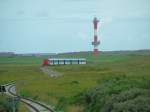 Ein  verschnrkelter  Schienenstrang schlngelt sich durch die Salzwiesen, dahinter der  neue  Leuchtturm. (06-08-29)