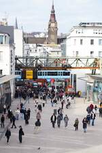 Über den Köpfen der Passanten verlässt ein Triebwagen der Wuppertaler Schwebebahn am 25.01.2025 die Station Hauptbahnhof