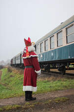 Der Nikolaus beobachtet den zum Halt kommenden Zug.Gleich wird er einsteigen und die Kinder beschenken. (Fürth im Ostertal, 1. Dezember 2024)