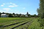 Die stliche Kurve vor dem Bahnhof und gleichnamigen Ort Binzen auf der Kandertalbahn, welcher im Hintergrund zu sehen ist.