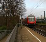 Ein RE4 von Dortmund-Hbf nach Aachen-Hbf und am Zugende ist die 111 122 DB kommt die Kohlscheider-Rampe hoch und fährt durch Kohlscheid in Richtung Richterich,Laurensberg,Aachen-West. 
Bei Regenwolken am Morgen vom 19.11.2015.
