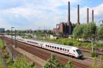 120 144-1 schiebt am 30.04.2014 den Ersatzzug Steuerwagen voraus aus Wolfsburg Hbf in Richtung Berlin Hbf (Tief), im Hintergrund sieht man das VW-Werk mit seinen vier markanten Türmen.