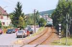 Ein Nahverkehrszug nach Bamberg war am 24.7.95 „Steuerwagen“ voraus im Bahnhof Ebern abgefahren. An der Stadtmitte (links vom Bild) fuhr er ohne Halt vorbei. Erst 2004 entstand hier ein Haltepunkt. Das gelbe Haus am linken Bildrand ist auch auf Bild ID 841129 zu sehen...