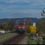 218 427 schiebt ihren IRE 4211 Ulm Hbf - Lindau Hbf am 4. April 2016 durch den Bahnhof Enzisweiler.