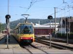 Stadtbahnwagen 567 kommt am 05.09.2004 auf der Linie S1 aus Richtung Bad Herrenalb und fhrt in den Bahnhof Ettlingen Stadt ein, um dann weiter ber Karlsruhe nach Hochstetten zu fahren. Links und rechts der strecke sieht man die Gebude des Ettlinger Betriebshofs der AVG, einem der Unternehmen des Karlsruher Verkehrs Verbundes. Die AVG betreibt die meisten der Stadtbahnwagen des KVV.