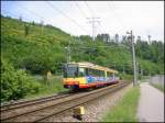 Stadtbahn-Triebwagen 575 ist am 15.05.2006 auf der Linie S11 zwischen Ittersbach und Karlsruhe-Neureut unterwegs. Die Aufnahme erfolgte auf dem Gebiet der Stadt Ettlingen, zwischen den Haltestellen Albgaubad und Spinnerei. Im Hintergrund sind die Hnge des Wattkopf zu sehen.