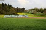 Seitlich 90-Grad-Ansicht auf den AVG-Triebwagen 880  Rizzibahn  vor frhlingshafter Kulisse bei Mnzesheim.