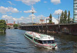 Während die  Spreekrone  auf der Spree fährt verlässt eine S-Bahn die Station Berlin Jannowitzbrücke.