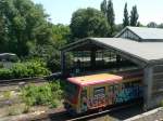 Eine arg verschandelte Ringbahn fhrt im Bahnhof Westkreuz ein.