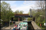 Während sich am 23.4.2016 ein Rundfahrt Schiff in der Schleuse des   Landwehrkanals in Berlin abwärts senkt, passiert eine S-Bahn im Hintergrund   die Kanalbrücke vom Bahnhof Zoo