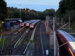 Während drei Hamburger S-Bahnzüge BR 472 des HVV ihre Sonntagsruhe genießen, rauscht rechts hinter der Schallschutzwand die Regionalbahn RB 21881 nach Büchen vorbei. Links im Bild: Blick auf das Gelände des Eisenbahnmuseums Lokschuppen Aumühle; 21.09.2008
