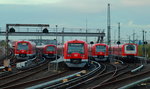 In der Abenddämmerung sind drei S-Bahn-Züge der Baureihe 474 und ein Zug der Baureihe 472/473 im Gleisvorfeld des Bahnhofes Hamburg-Altona abgestellt, rechts fährt ein 474 in Richtung Elbgaustraße aus (30.10.2016)