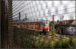 Hinter einem Schleier aus Metall -     Ein S-Bahnzug erreicht gleich den Bahnhof Bad Cannstatt.