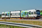 Saarbahntriebwagen auf einem Schwerlastanhänger, abgestellt auf einem Abstellplatz an der A 61 bei Meckenheim. Unterwegs nach Köln zur KVB wegen der Durchführung einer Hauptuntersuchung - 19.07.2016