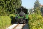 Ein Zug der Chiemseebahn auf dem Streckenabschnitt entlang des Eschenweges in Prien.