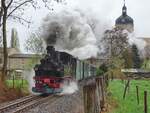 An einem grauen Apriltag im Jahr 2017 dampft 99 574 der Döllnitzbahn von Mügeln vorbei am Schloß Ruhethal nach Glossen.