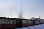 Bahnhof Brocken am 25.01.2013 gegen 17.00 Uhr. Am Gleis 1 steht P8936 nach Wernigerode bereit. In der kleinen Nebelbank sind der Aussichtsturm und der alles berragende markante Sendemast zu erkennen. Im Gebude hinter dem Bahnhof (mit Kuppel) befand sich zu DDR-Zeiten ein Stasi-Abhrposten mit hochempfindlichen Anlagen, welche weit hinein ins westliche Ausland zum  Klassenfeind  reichten! Heute befindet sich dort ein sehr interessantes Museum zur Brockengeschichte, wo auch Flora und Fauna sehr anschaulich erklrt werden. Auch die Original-Abhranlagen sind noch vollstndig erhalten und knnen besichtigt werden! Wenn man bedenkt, dass das damals strengstens abgeschirmtes militrisches Sperrgebiet war, dann wird einem beim Betrachten heute noch mulmig!!