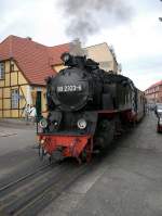 99 2323-6 auf der Fahrt durch die Doberaner Innenstadt.